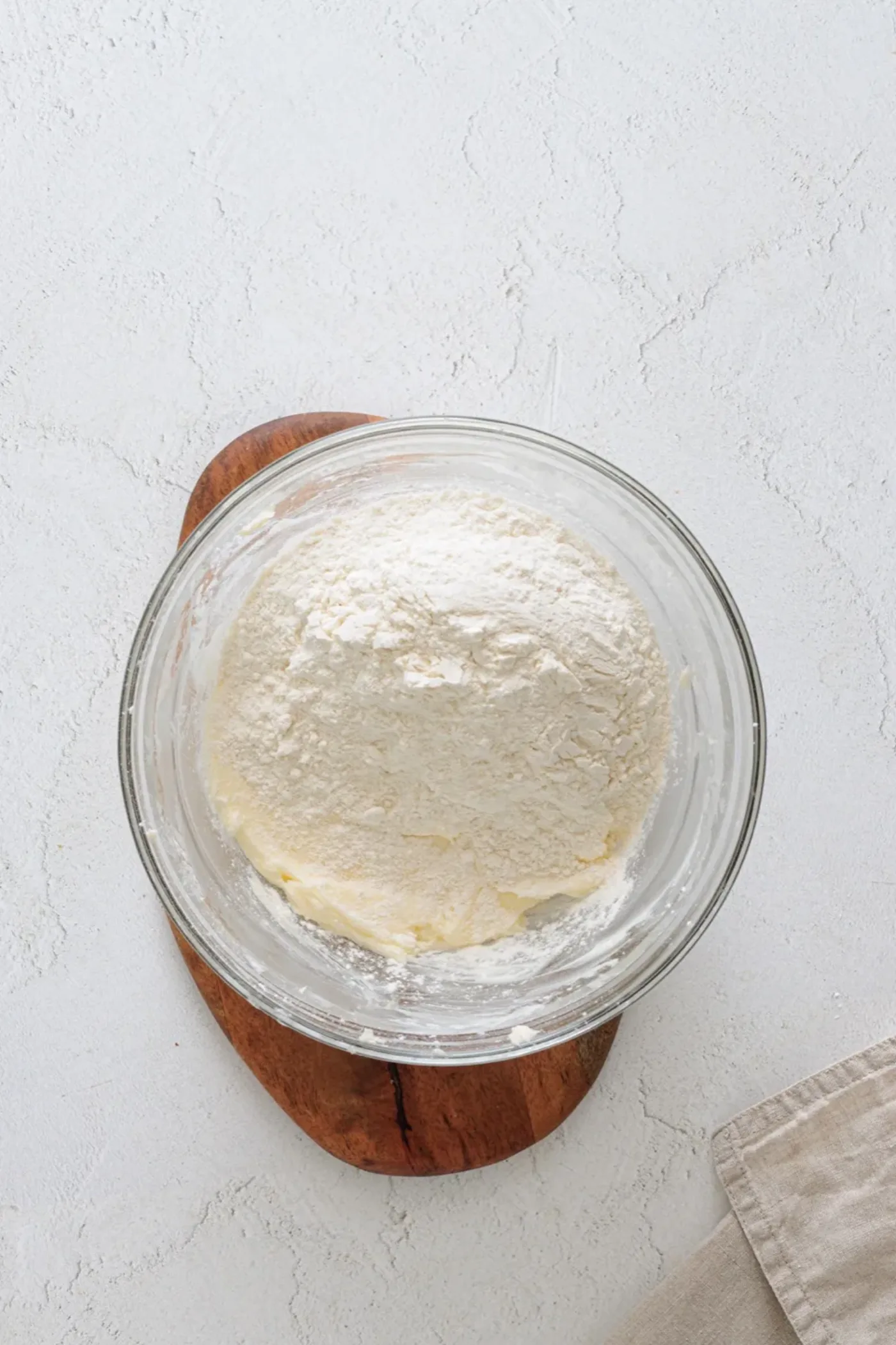 Flour added over the creamed butter mixture in a bowl