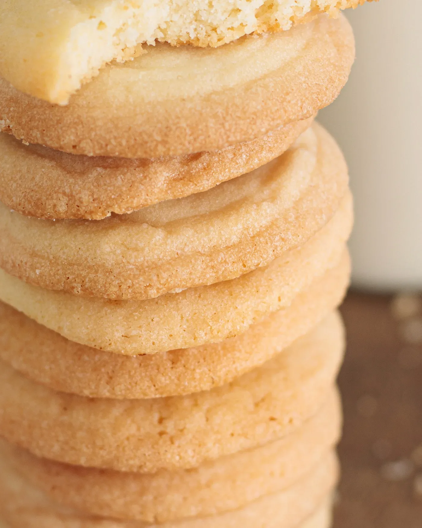 Stack of golden butter cookies with one broken cookie showing its crumb