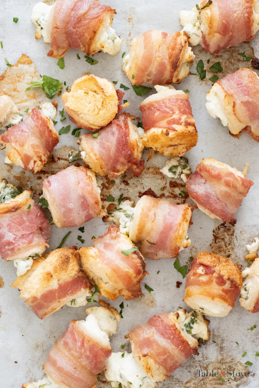 Golden baked bacon-wrapped bread bites on a baking sheet