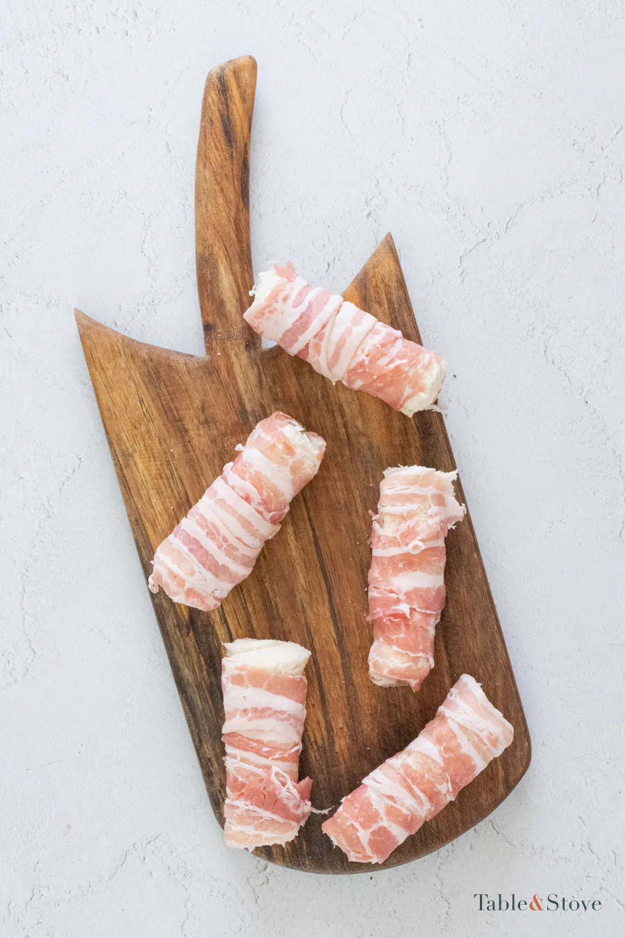 Five bread rolls spiraled with strips of bacon