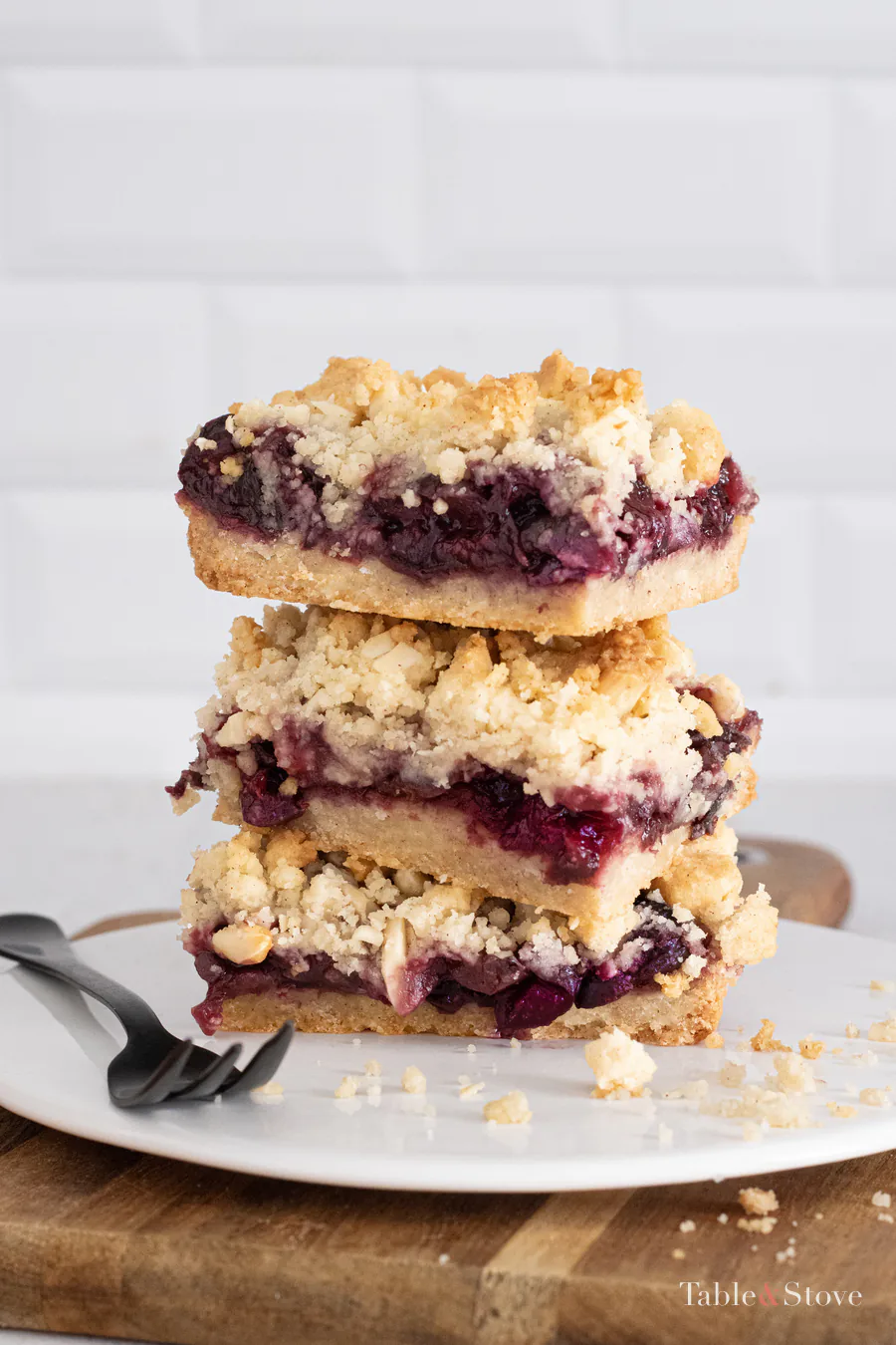 Stack of cherry pie bars showing the fruit layer and almond crumble