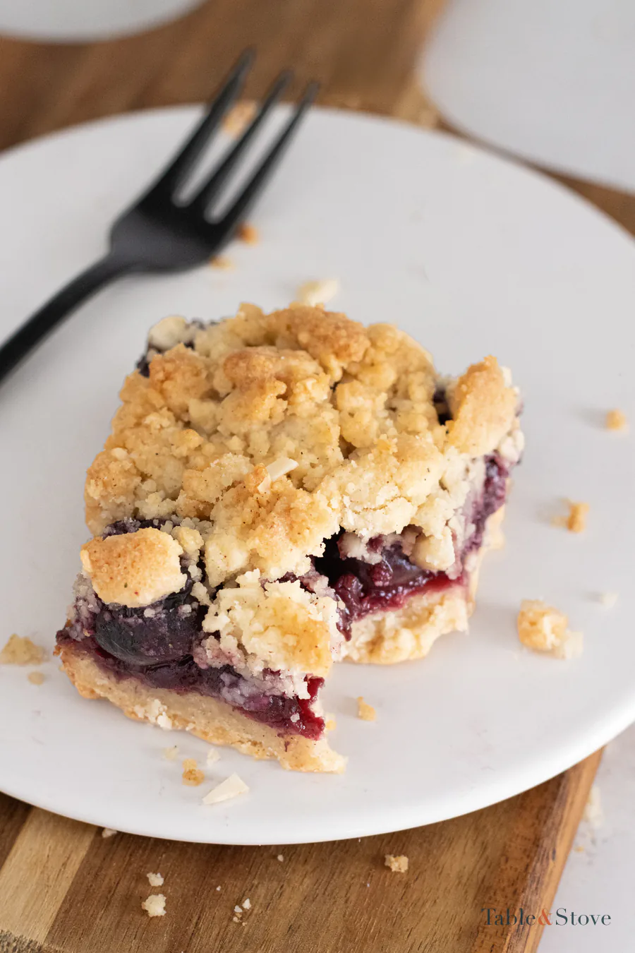 Single cherry pie bar on a white plate with a fork