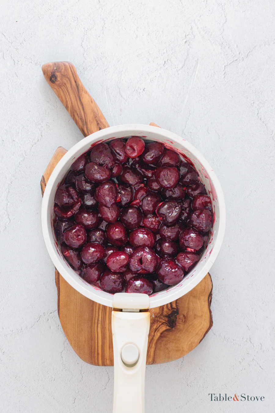 Thickened cherry filling in a white saucepan