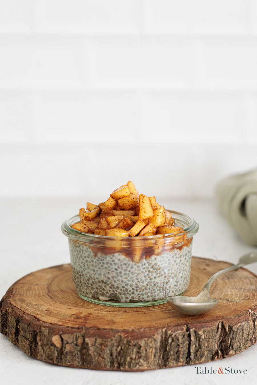 Apple cinnamon chia pudding topped with cooked apple cubes in a glass jar