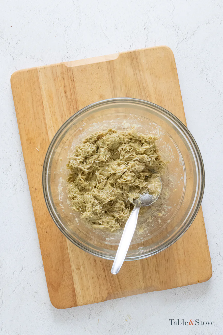 Toasted kataifi mixed with pistachio cream and tahini in a glass bowl