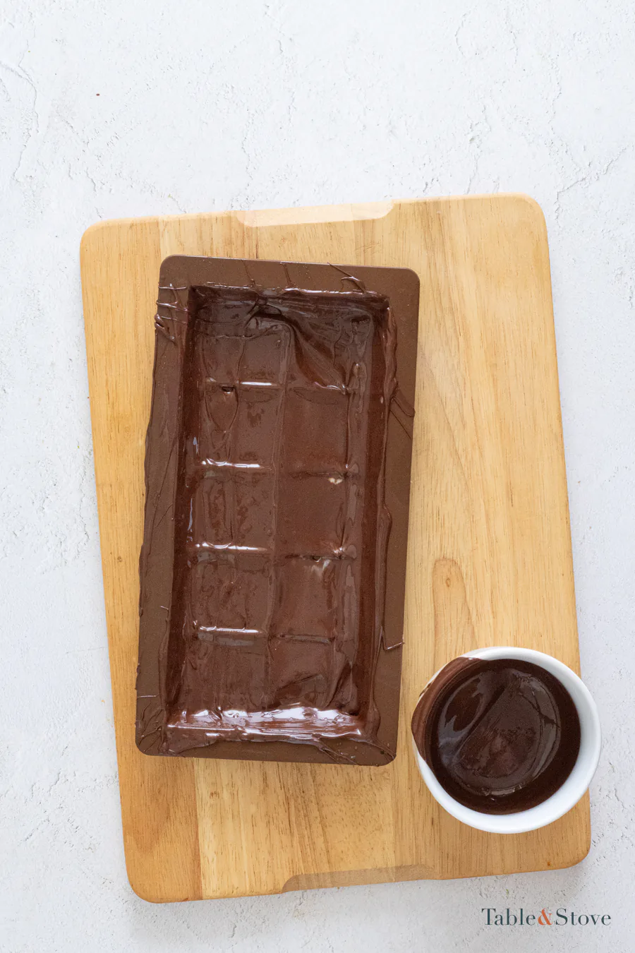 Dark chocolate coating the bottom and sides of a rectangular mold