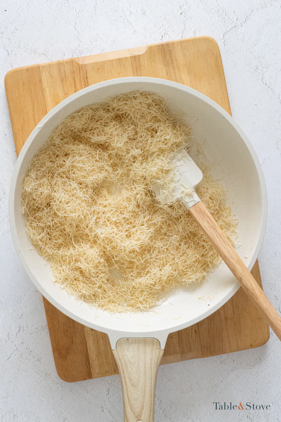 Golden toasted kataifi strands in a frying pan