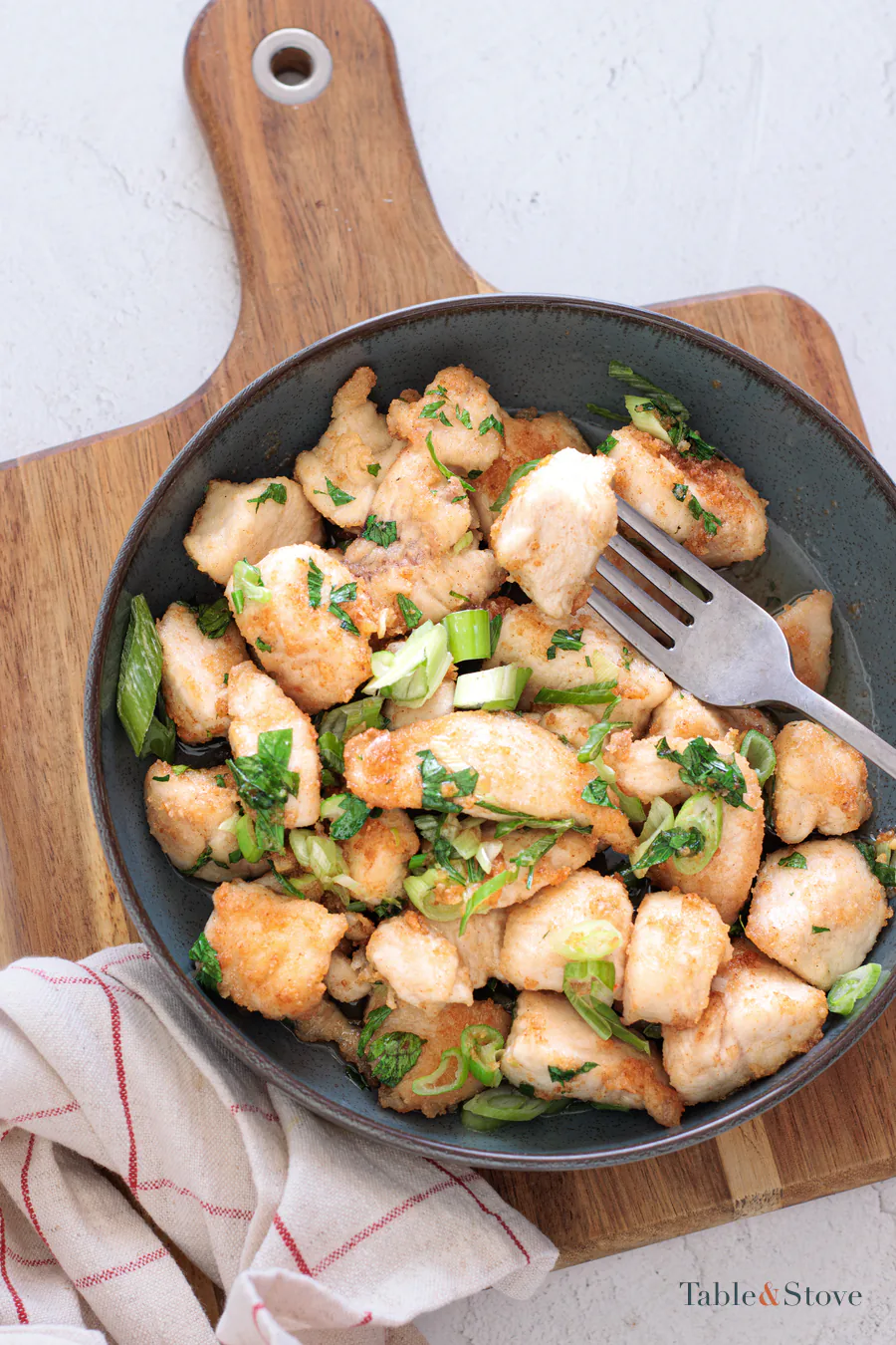 Garlic butter chicken bites coated in pan sauce with green onion and parsley
