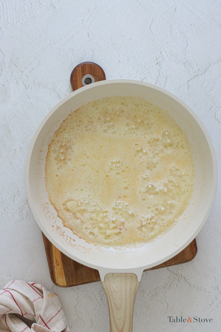 Pale bubbling pan sauce reducing in a skillet