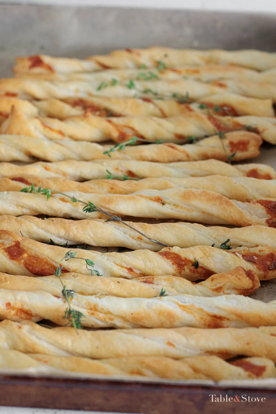 Close view of golden garlic Parmesan twists on the baking sheet