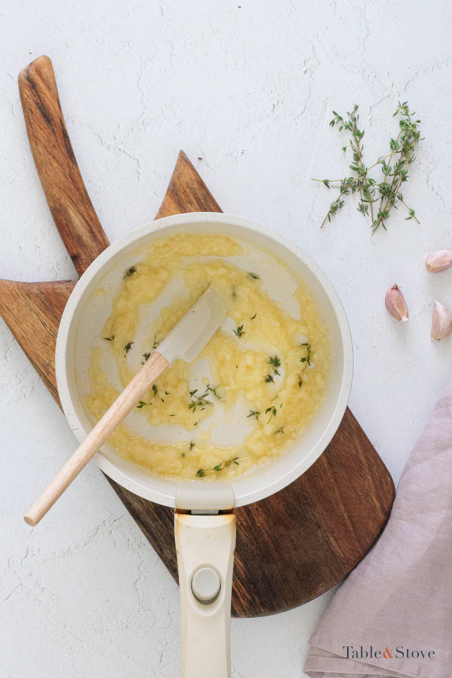 Melted butter mixed with garlic, Parmesan, and thyme in a small saucepan