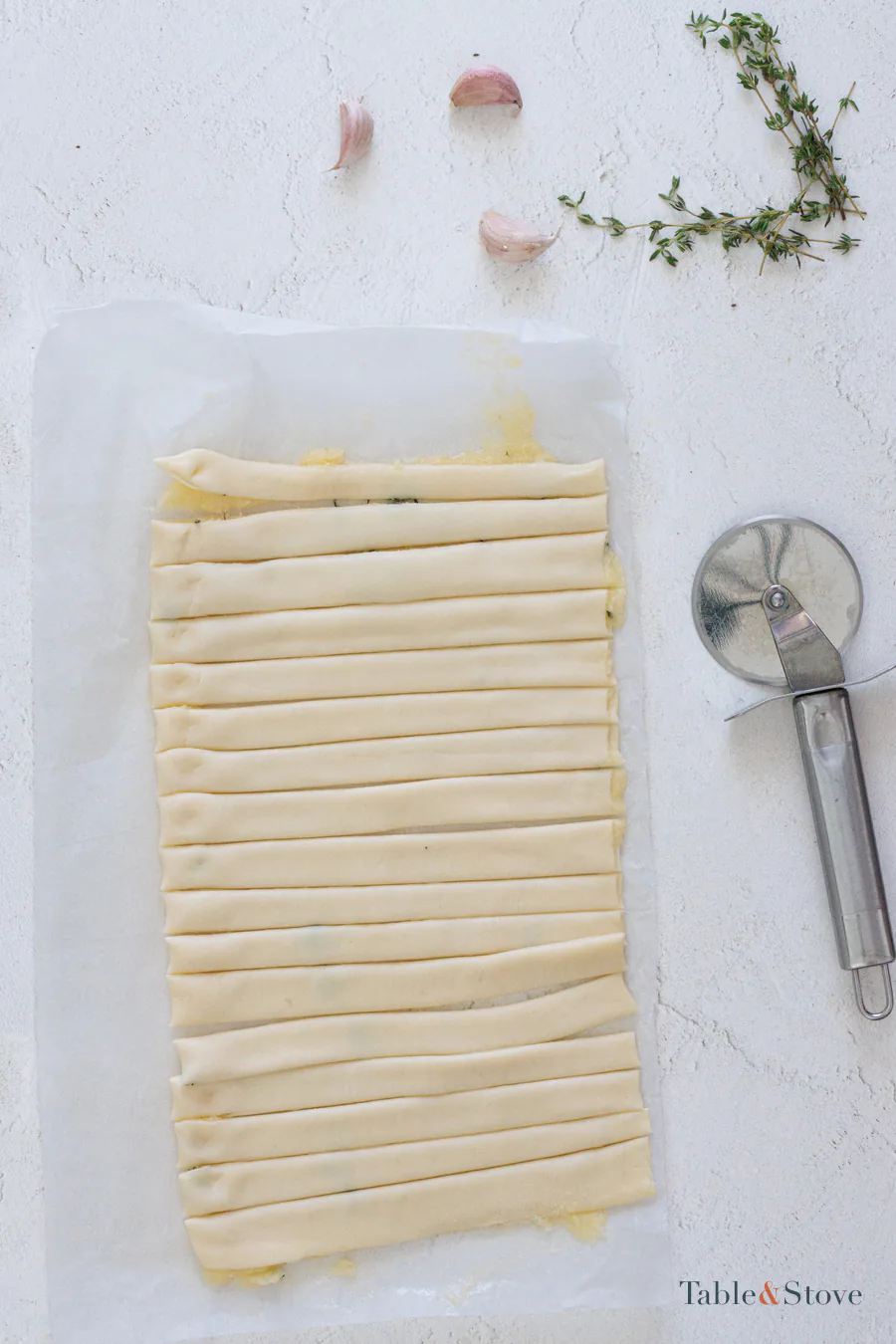 Folded puff pastry cut into narrow even strips with a pizza cutter