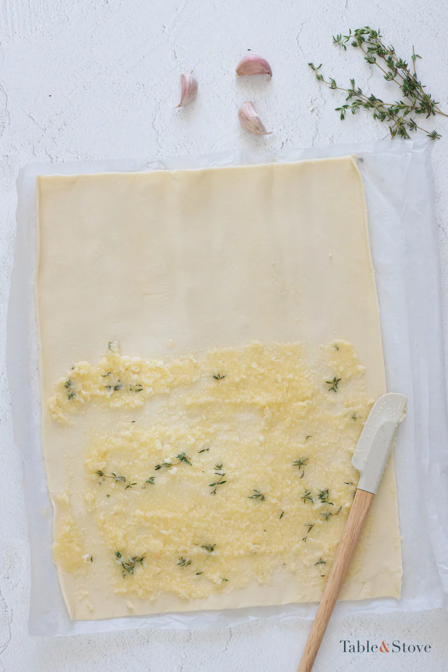 Garlic Parmesan butter spread over one half of a puff pastry sheet
