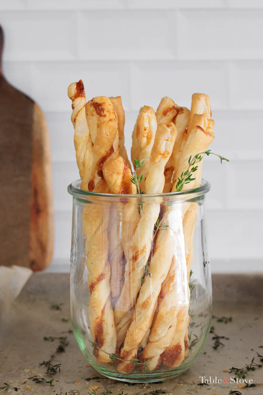 Golden garlic Parmesan puff pastry twists on a serving board