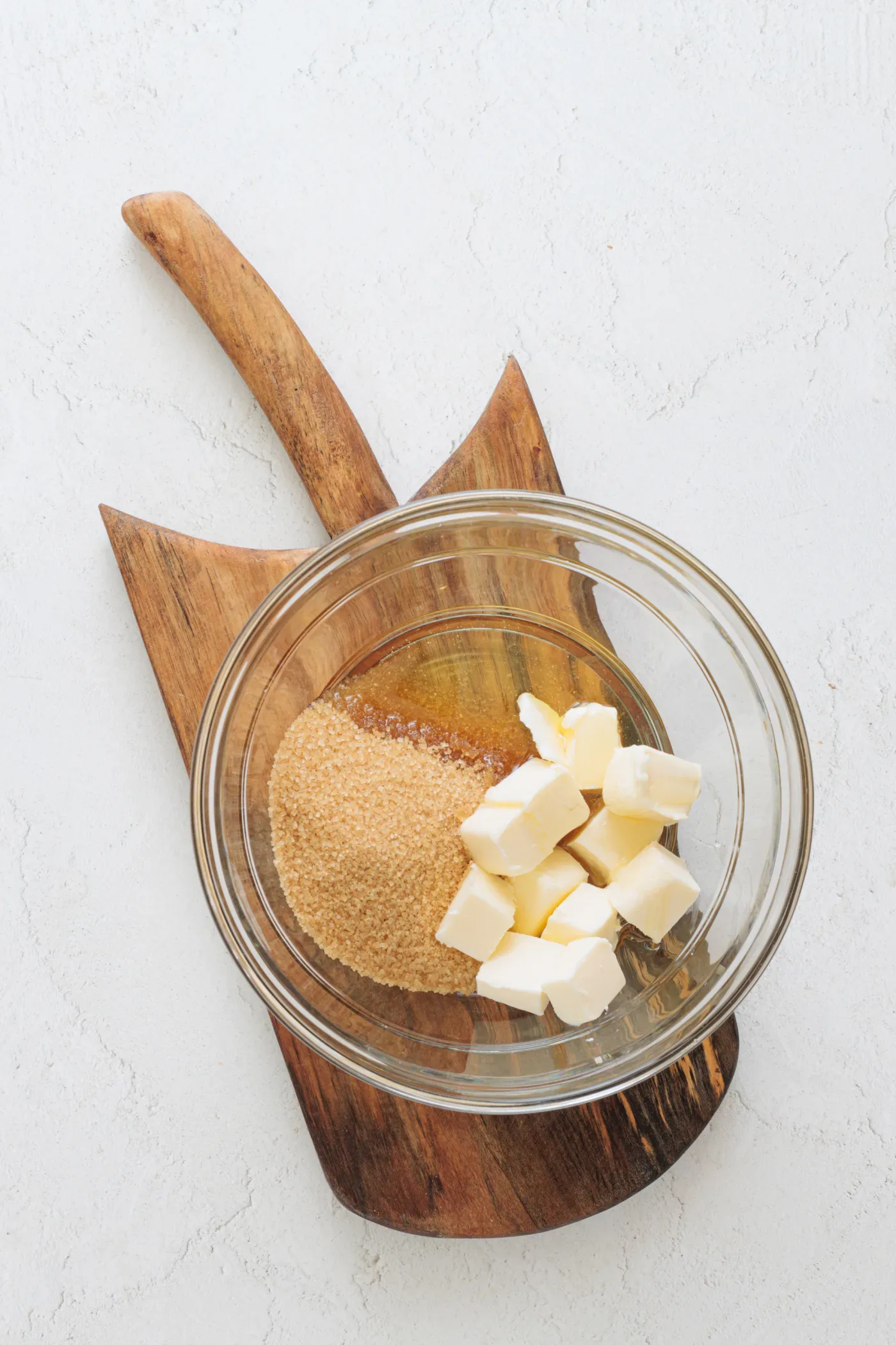 Butter and light brown sugar in a glass mixing bowl with honey and sunflower oil ready to add