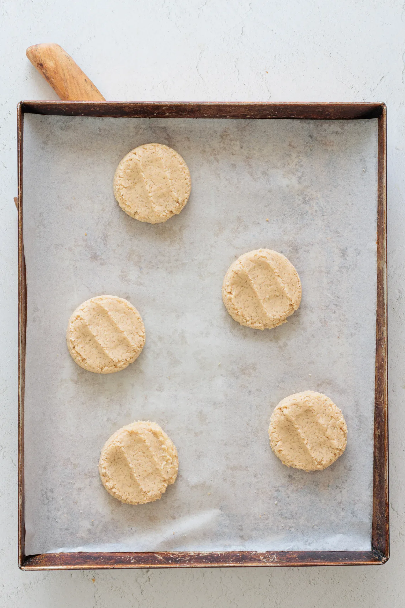 Honey cinnamon cookie dough balls spaced on a parchment-lined baking sheet