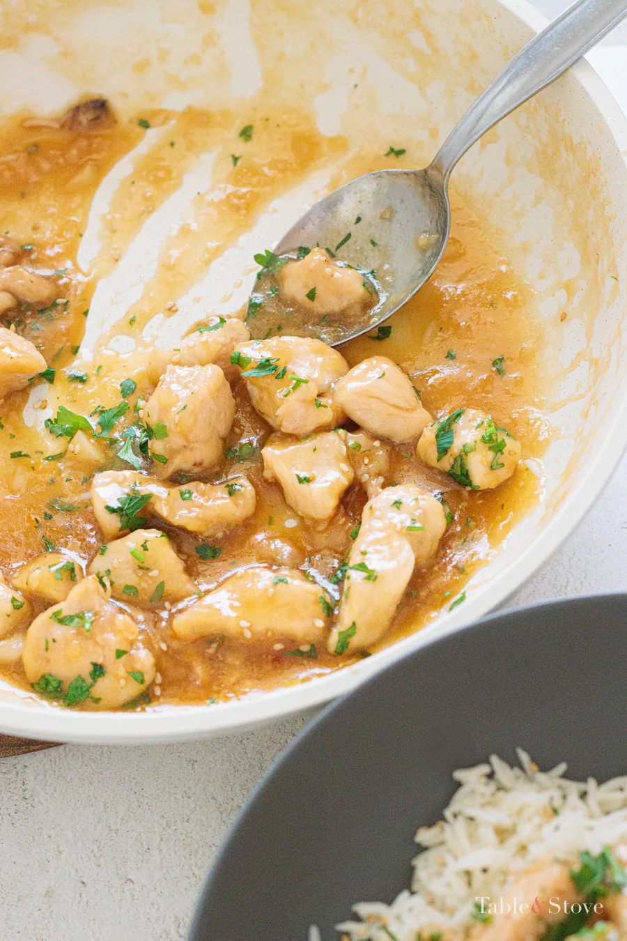 Close view of honey garlic chicken and thick sauce in the skillet