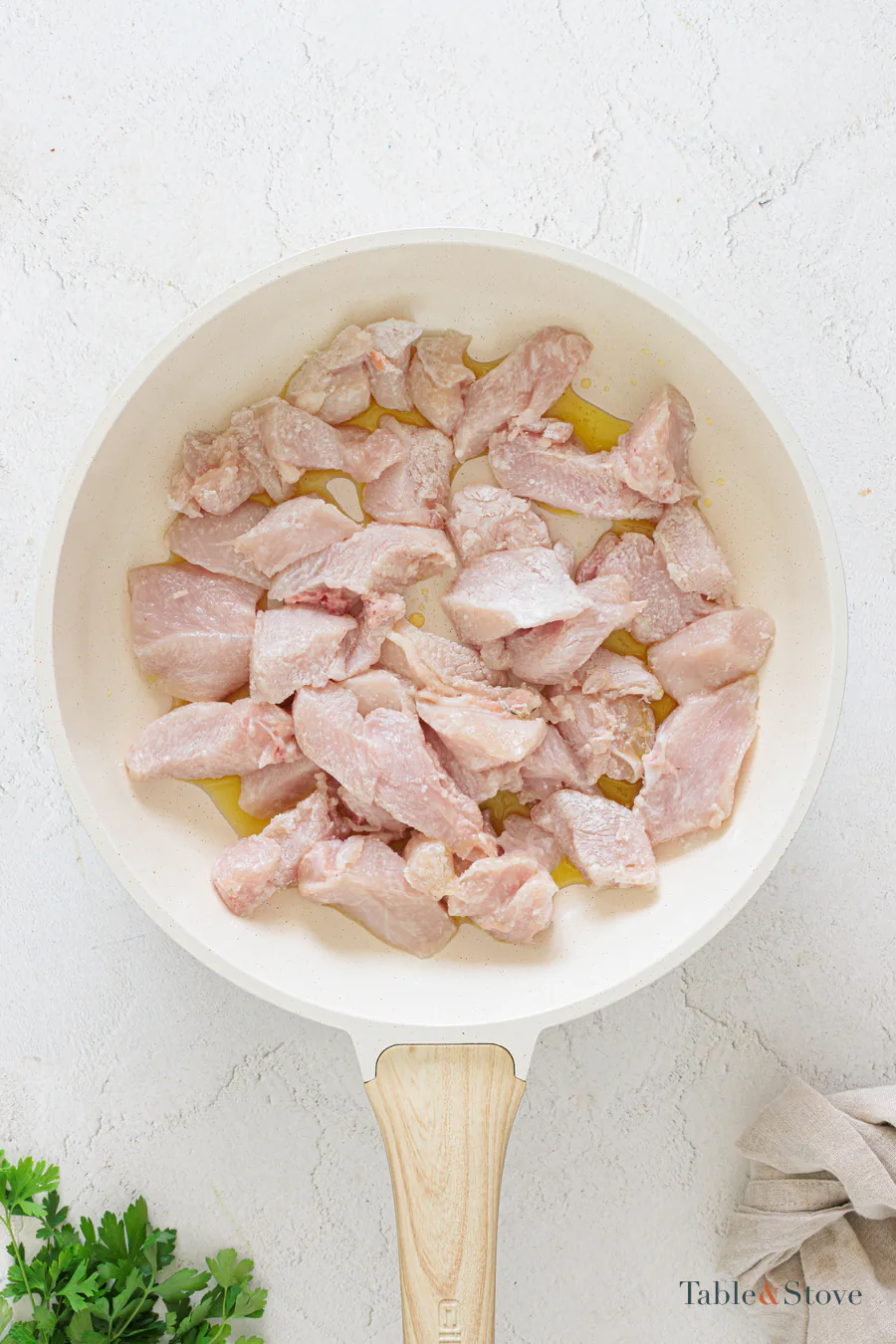 Coated chicken pieces arranged in a single layer in a skillet