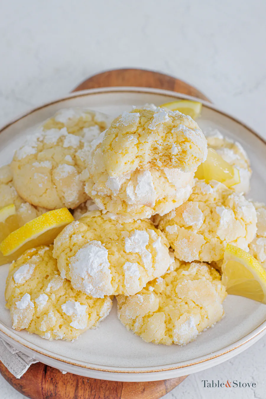 Plate of finished lemon crinkle cookies with lemon wedges
