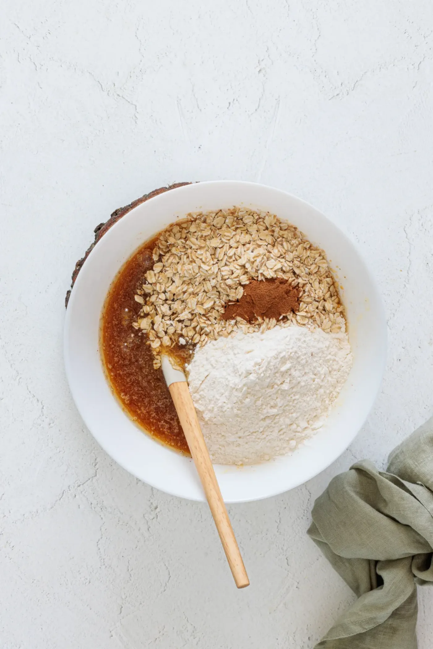 Flour, oats, cinnamon, and baking powder added to the cookie mixture