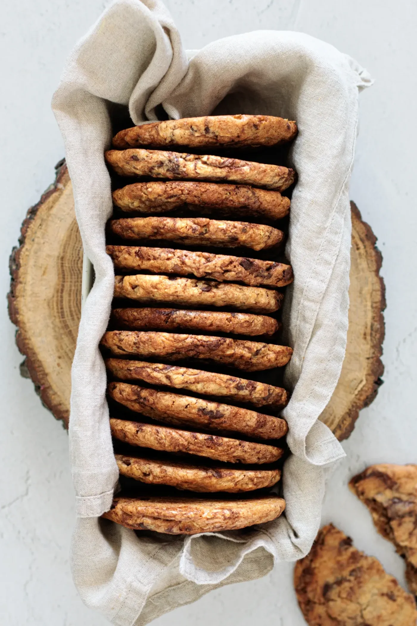 Stack of baked brown butter cookies in a cloth-lined tray