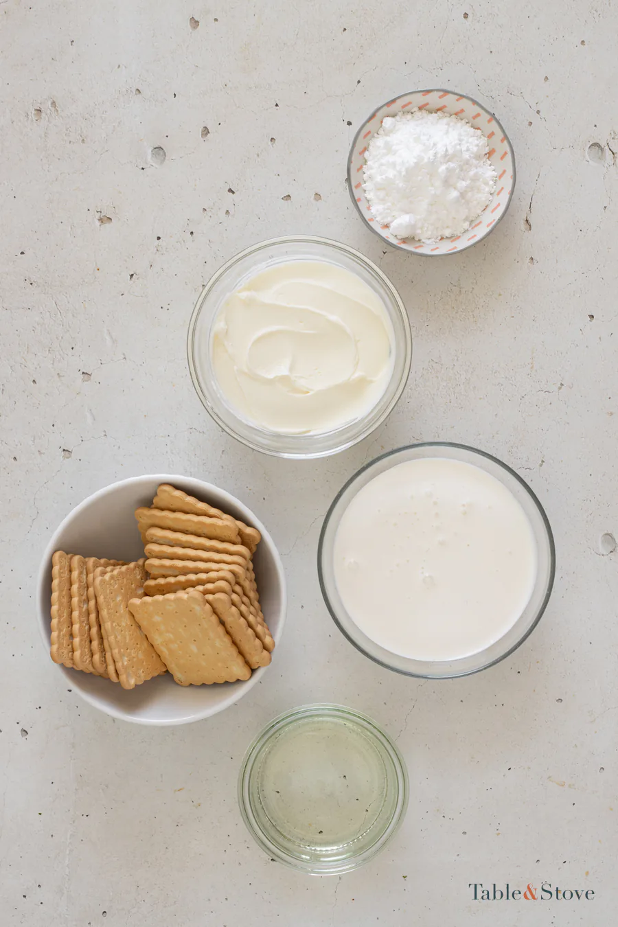 Dry cookies, cream cheese, whipping cream, powdered sugar, and sunflower oil arranged in bowls