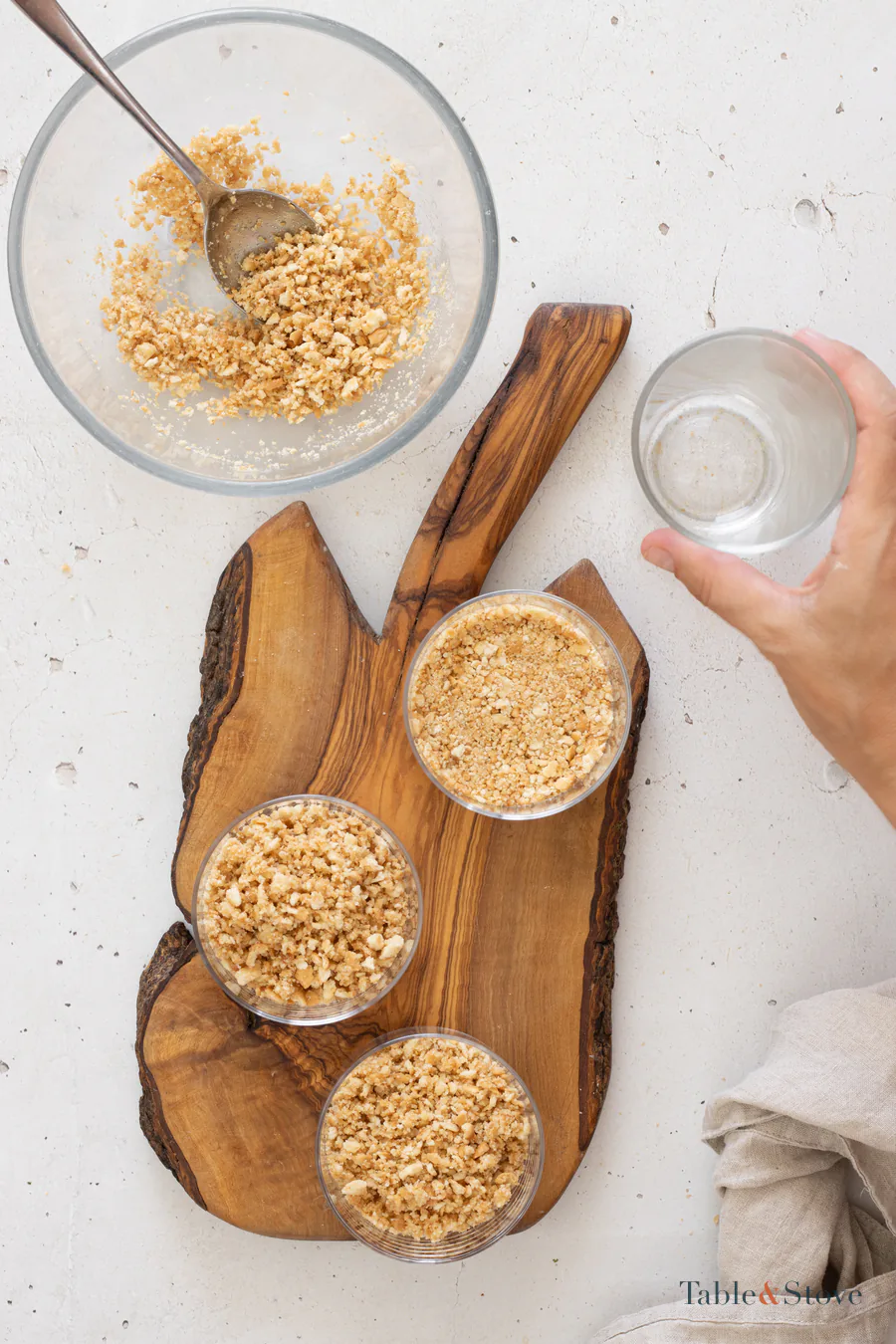Cookie bases being pressed into serving glasses with the bottom of another glass