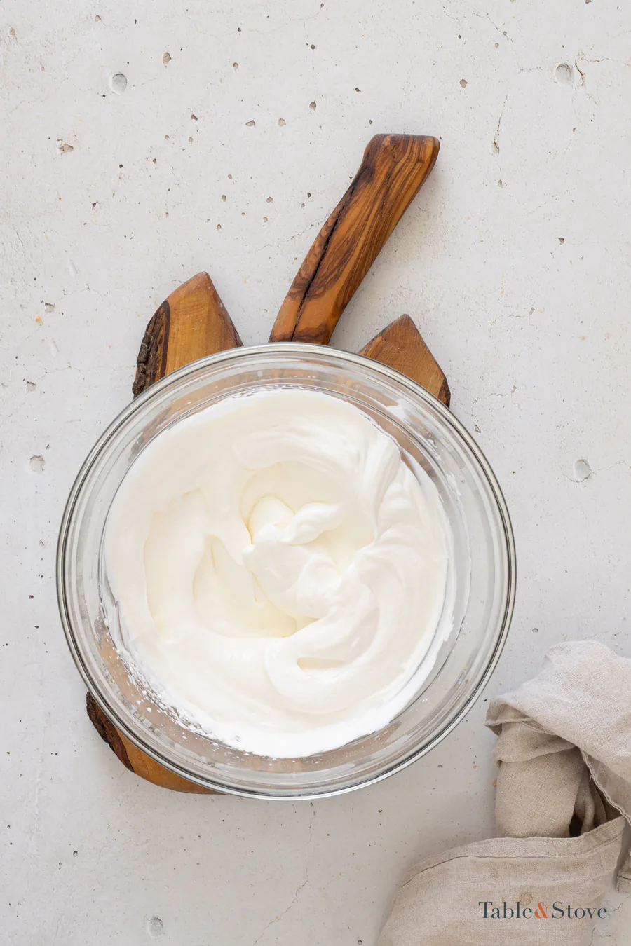 Smooth whipped cheesecake filling in a glass mixing bowl