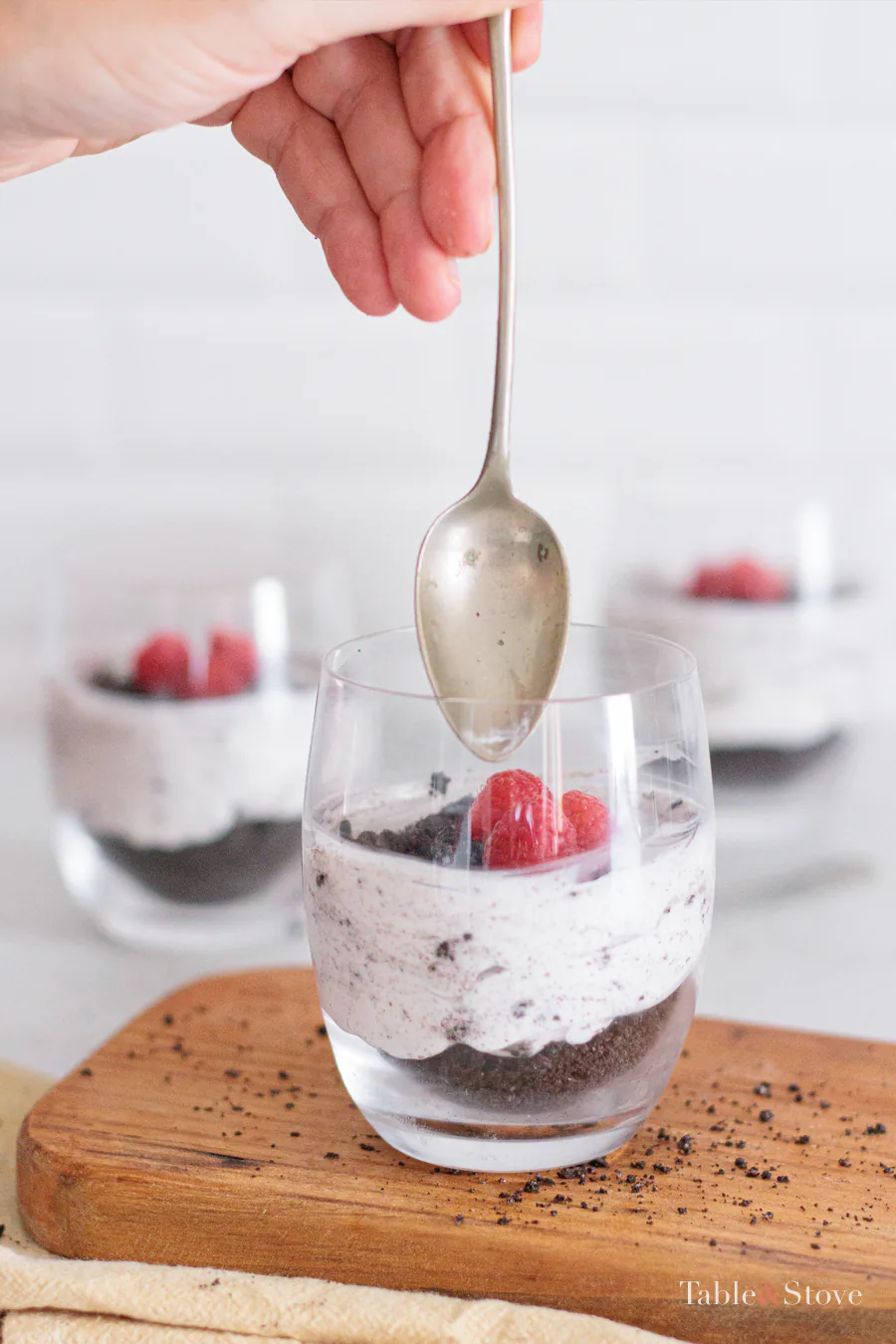 Spoon lifted above a layered Oreo dessert cup