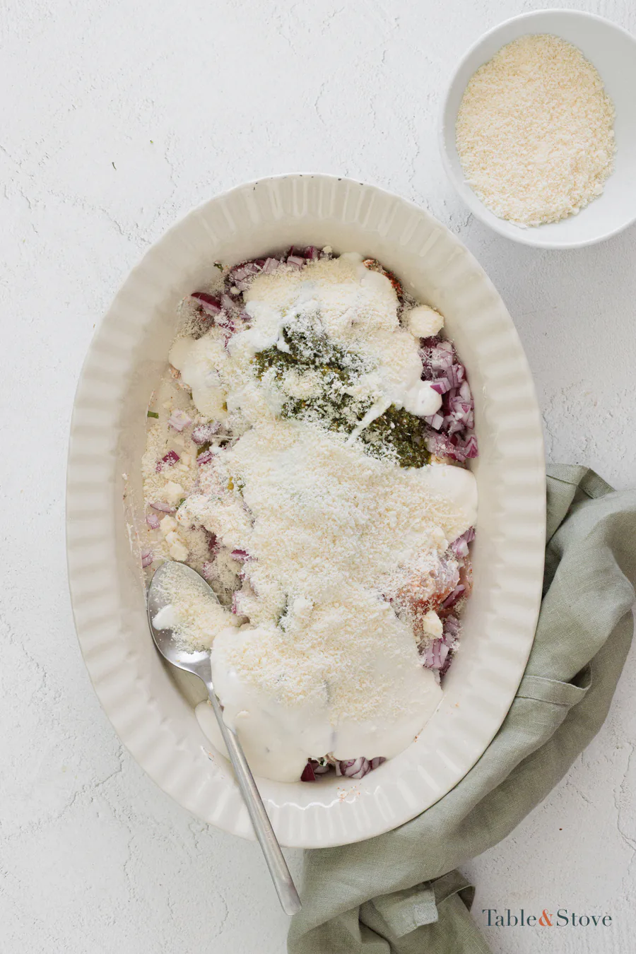 Chicken topped with chopped onion, salsa verde, cream, and grated Parmesan