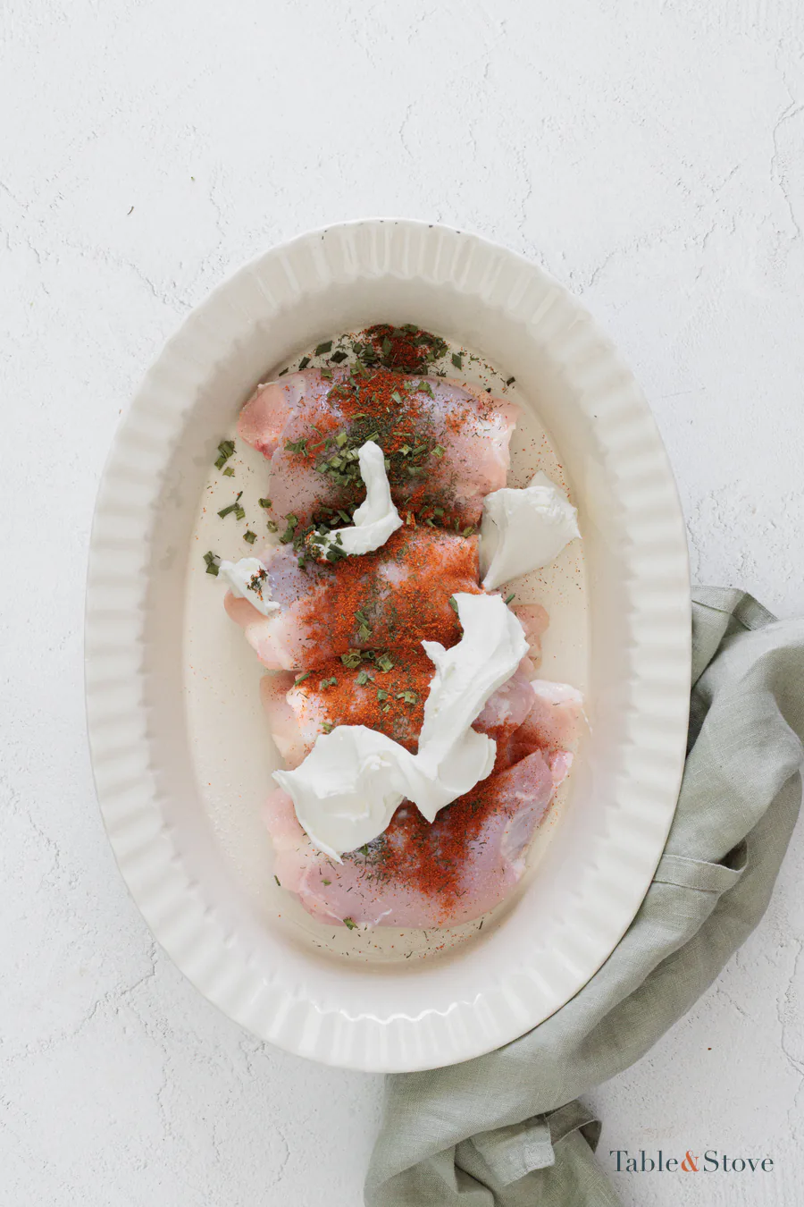 Chicken thighs topped with cream cheese, dried herbs, paprika, salt, and pepper
