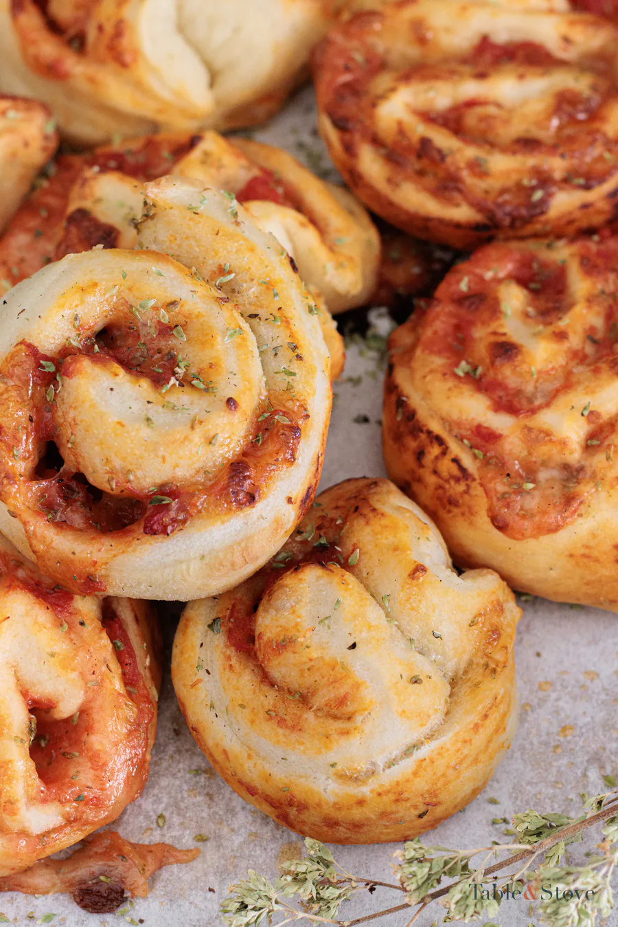 Close view of golden pizza pinwheels with tomato and mozzarella
