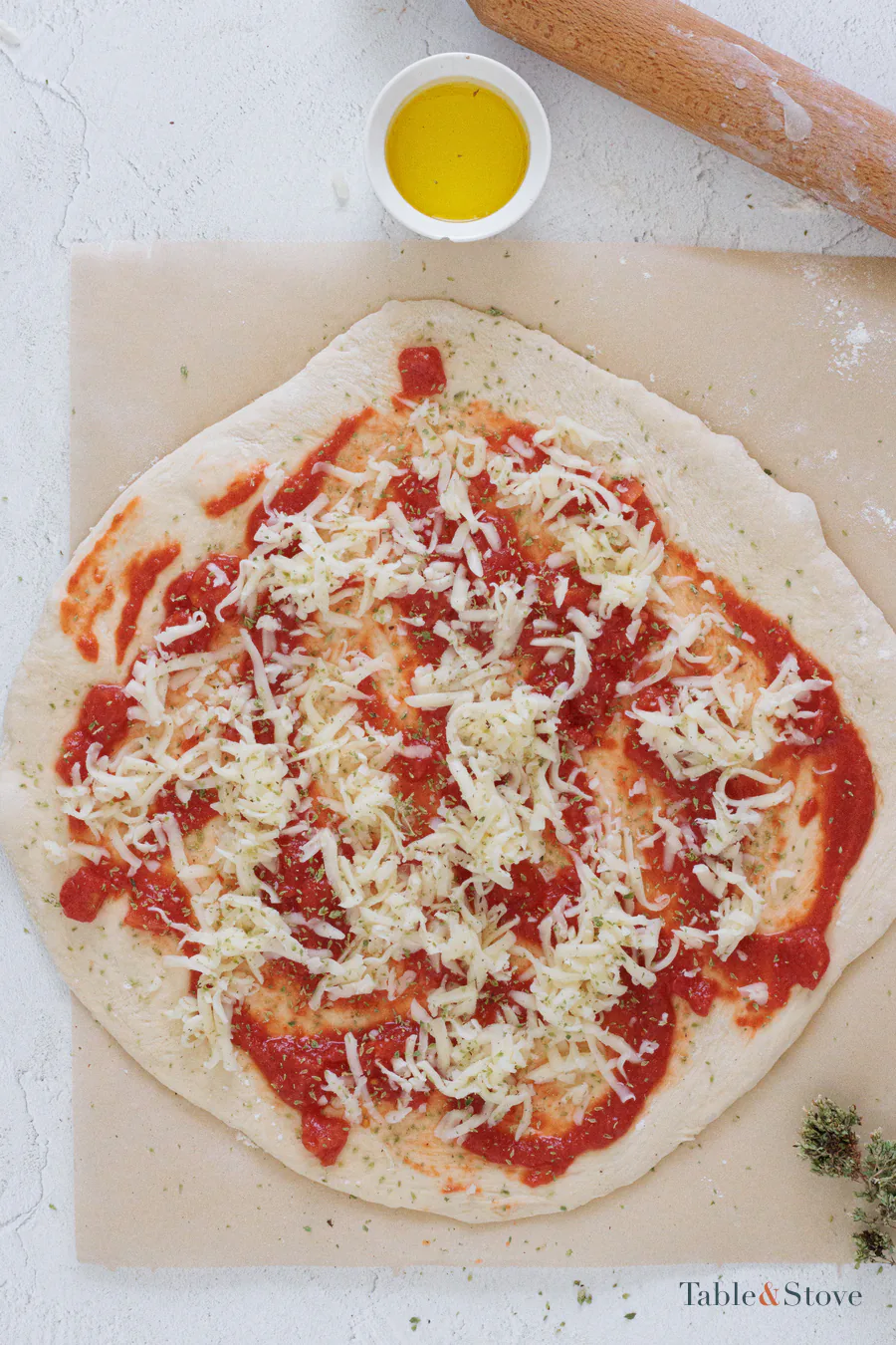 Rolled pizza dough spread with tomato and topped with mozzarella and oregano