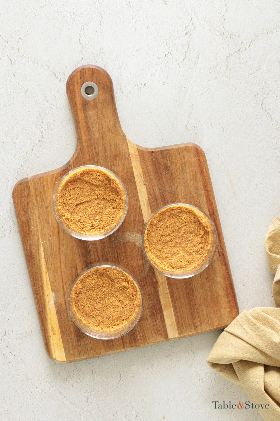 Three clear glasses with cookie crumbs pressed into their bases