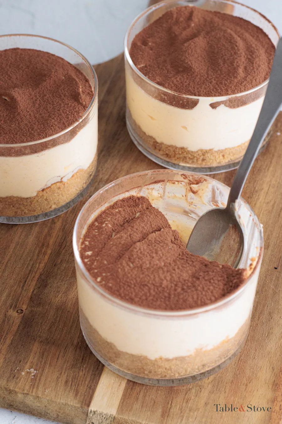 Pumpkin cheesecake cups dusted with cocoa, photographed from above