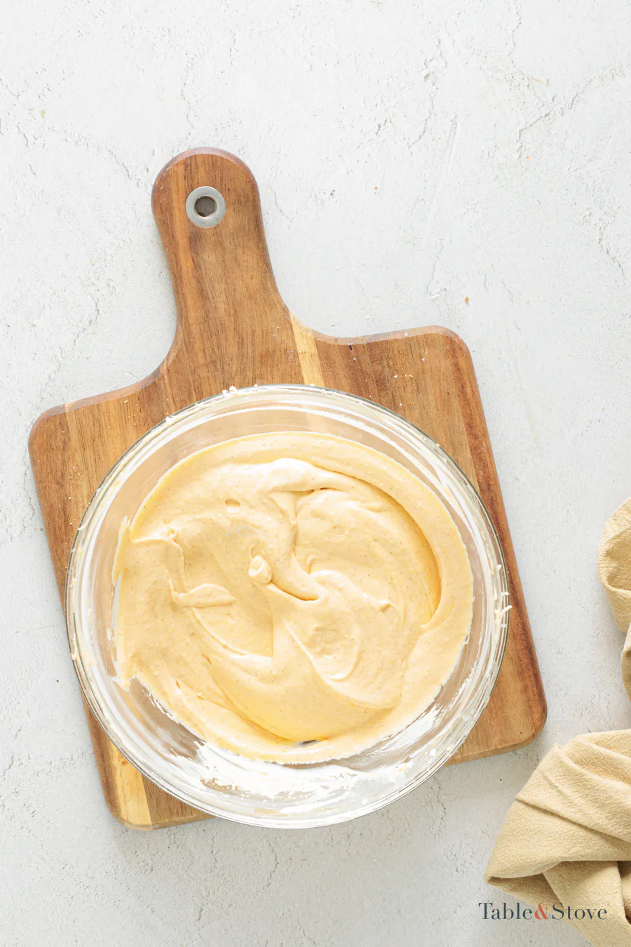 Smooth pale orange pumpkin cheesecake filling in a mixing bowl