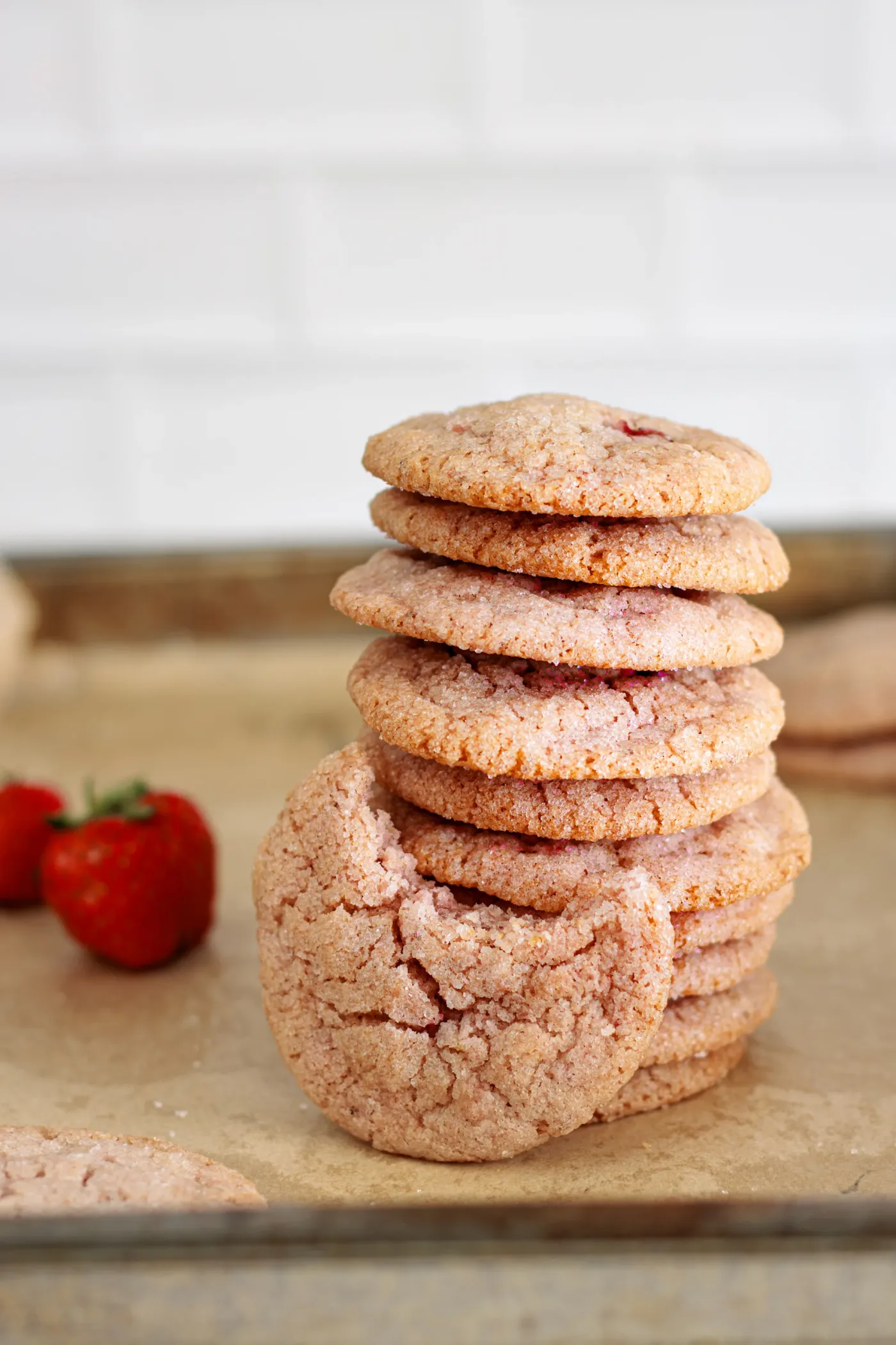 Stack of baked strawberry sugar cookies on parchment paper