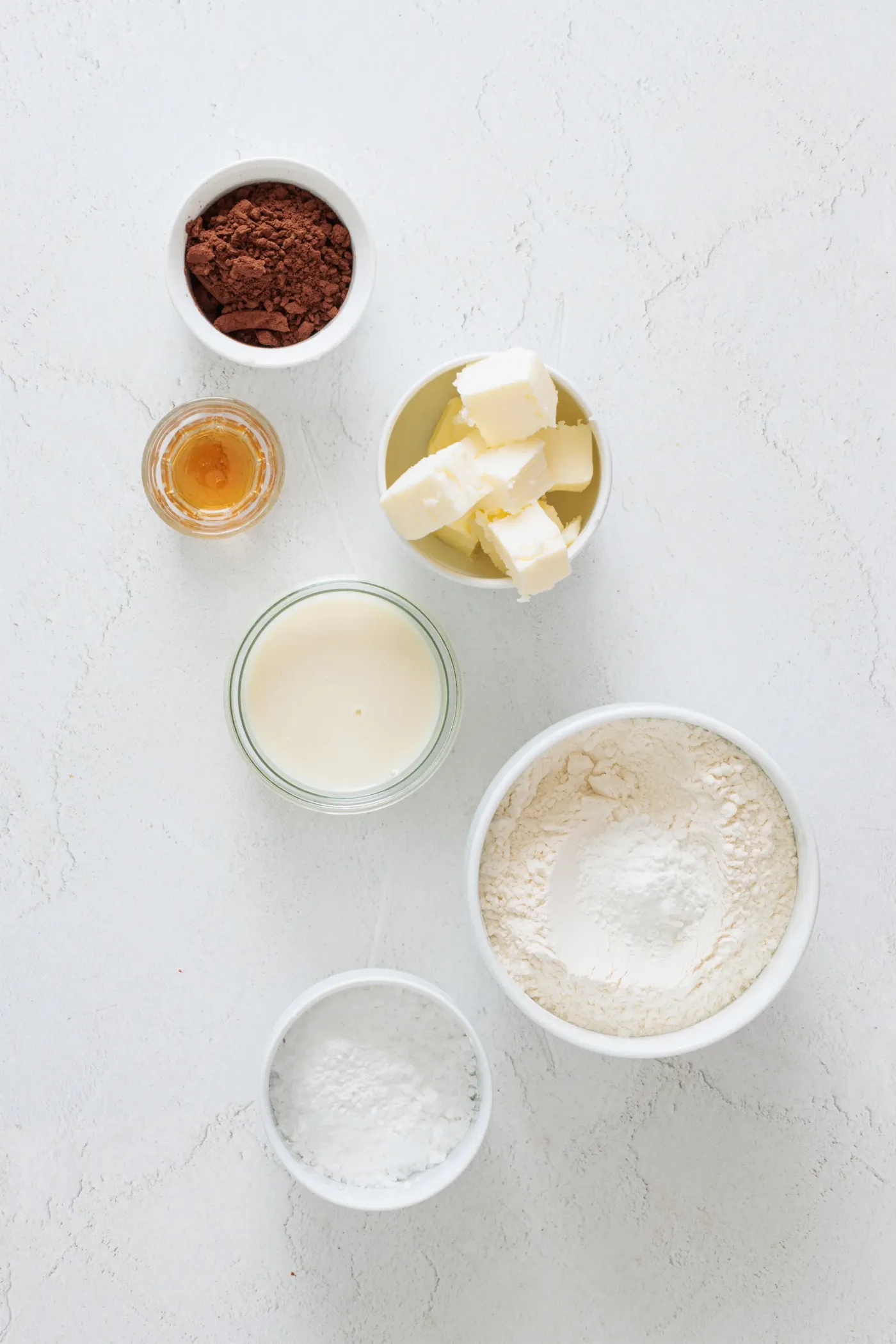 Measured butter, flour, cocoa powder, powdered sugar, milk, and vanilla for zebra cookies