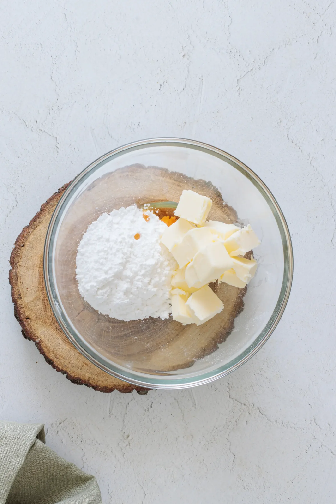 Softened butter, powdered sugar, and vanilla in a glass bowl