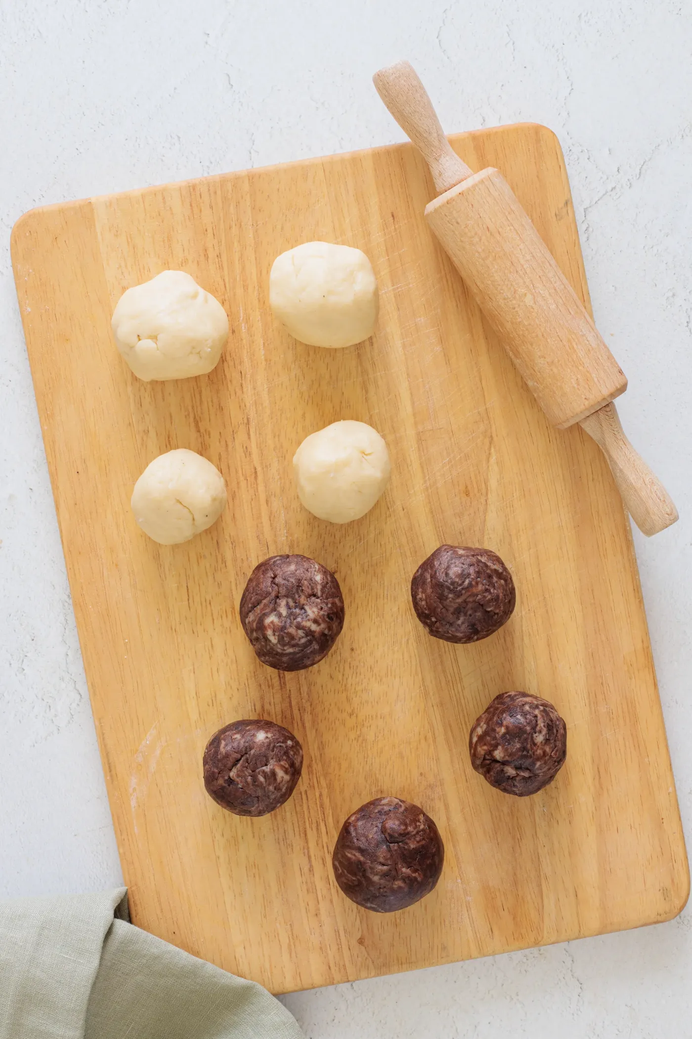 Plain and cocoa cookie dough pieces on a wooden board